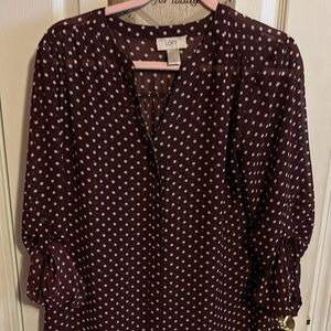 Long-sleeved Sheer Loft polka dot blouse with roll up sleeves.